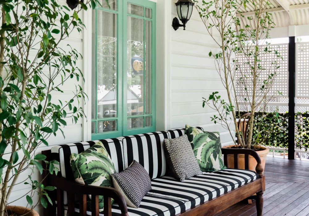 Photo of wooden chair on wooden deck with green door