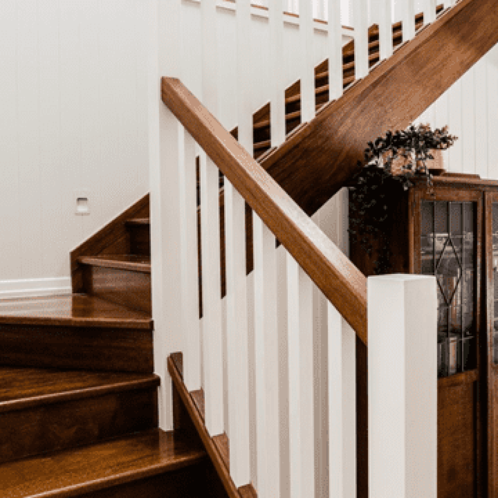 Wooden stairs with white spindles and a light, bright home.